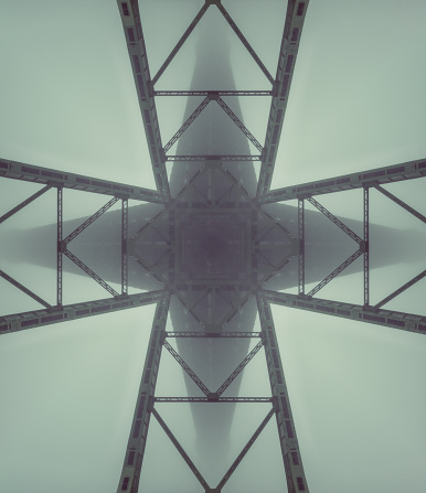 Suspension bridges converge in fog high above.  Composite image.