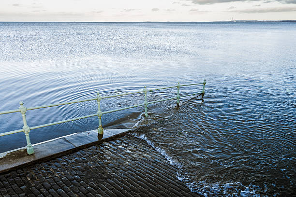 Rising Sea Rising sea levels submerging a walkway under water. view into land stock pictures, royalty-free photos & images