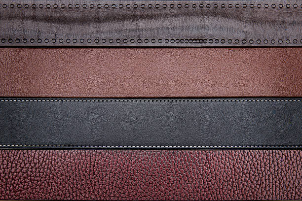 istock Dark leather belts close-up texture background 477957216