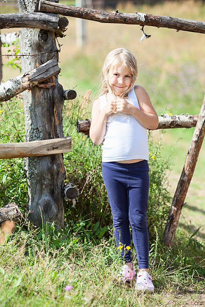 美しい少女によるホワイトに近い singlet フェンス - child little girls shy standing ストックフォトと画像