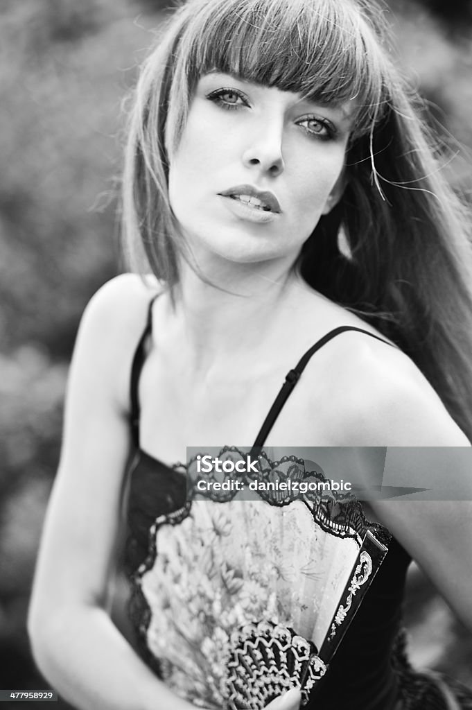 Woman with Hand Fan Portrait of young woman with hand fan.Black and white photo. Selective focus. Adult Stock Photo