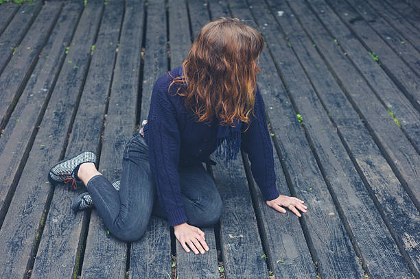 istock Young woman sitting on wooden deck 477959784