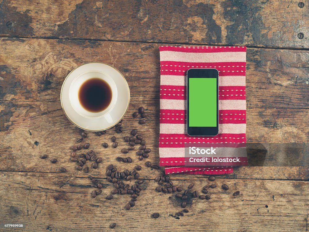 Coffee concept with cup and a smart phone Overhead shot of coffee concept with cup, beans, tea towel and a smart phone with a green screen 2015 Stock Photo