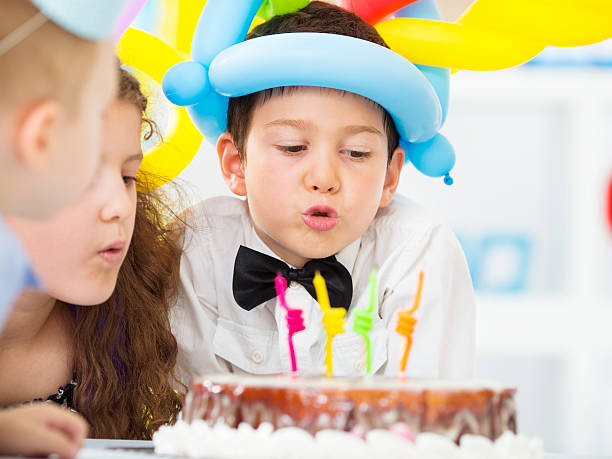 istock Cheerful Children Blowing Birthday Candles. 477961977