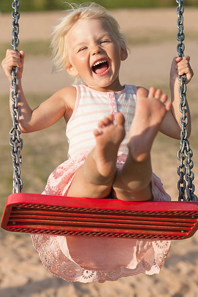 istock Cute little girl laughs while swinging 477963139
