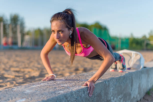 istock Fitness woman doing push ups Outdoor training workout summer evening 477968882