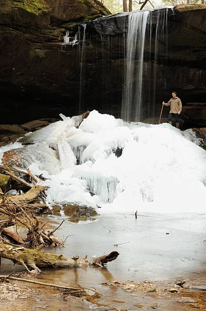 istock Man standing near waterfall in winter 477971115