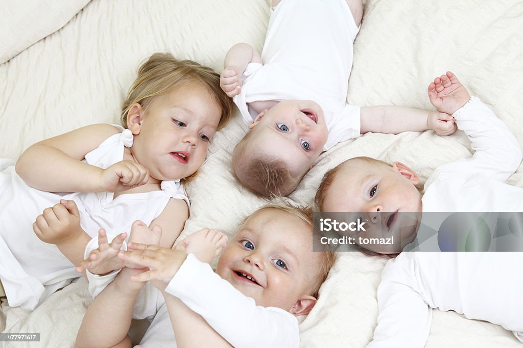 Niños en la cama - Foto de stock de Familia con cuatro hijos libre de derechos