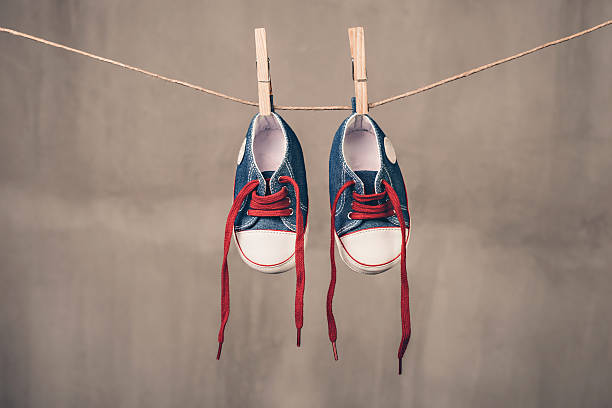 istock Baby sneakers hanging on the clothesline 477972800