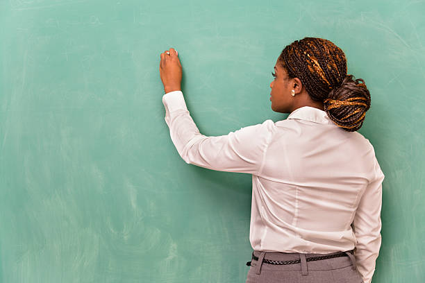 negócios e educação: jovem mulher escrevendo em branco chalkboard. - blackboard writing chalk teacher - fotografias e filmes do acervo