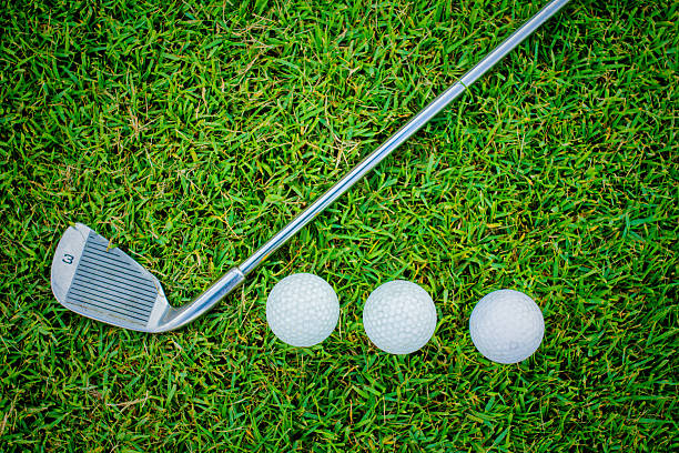 istock golf ball in grass and golf club 477985496