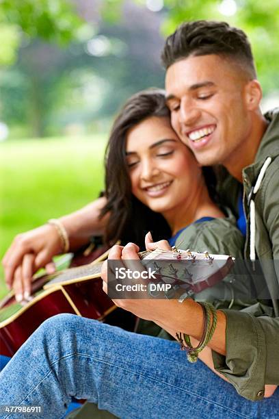 Foto de Alegre Casal Jovem Tocando Guitarra No Parque e mais fotos de stock de 20 Anos - 20 Anos, 20-24 Anos, Adulto