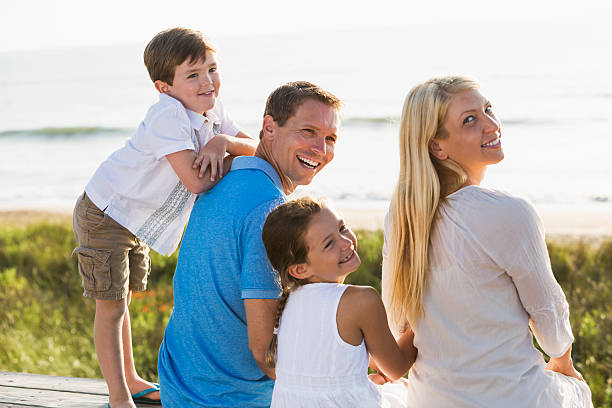 istock Family of four at beach 477988518