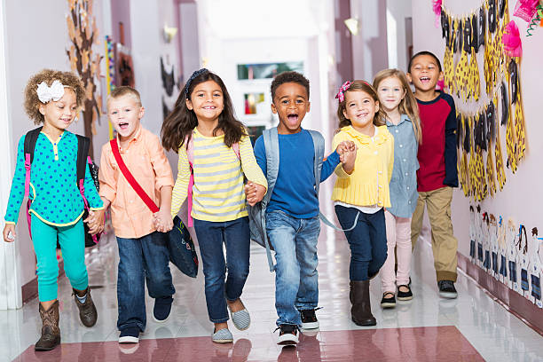 istock Multiracial group of preschoolers running down hallway 477988890