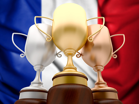 Sport Background with 3 Trophy Cups and unfocused France Flag on the background