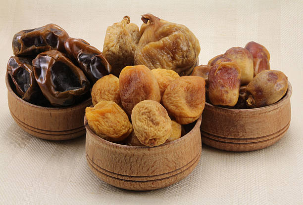 istock Dried figs, dates, dried apricots in a wooden circular shape 477989518