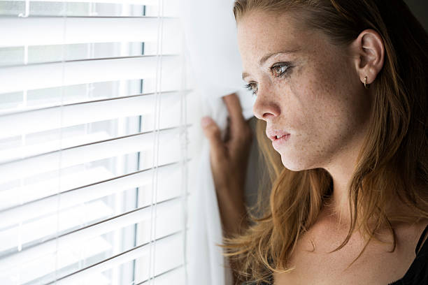 istock Sad young woman with smeared makeup by the window 477991729