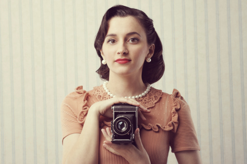 Beautiful young woman with a old camera