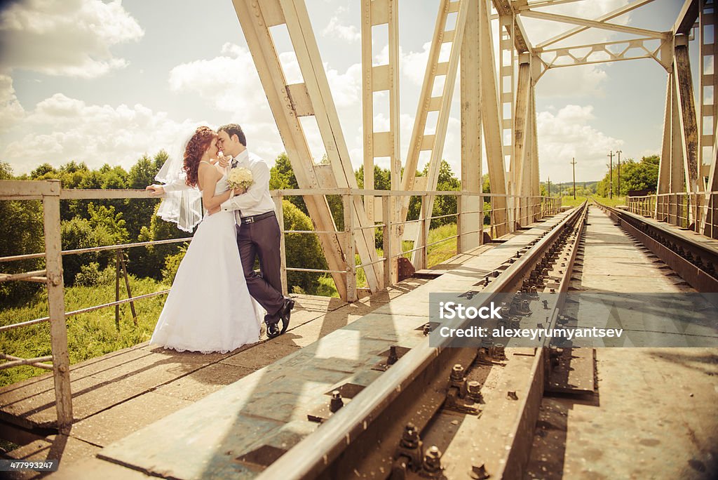 wedding couple at bridge young wedding couple sharing their feelings at railway bridge Adult Stock Photo