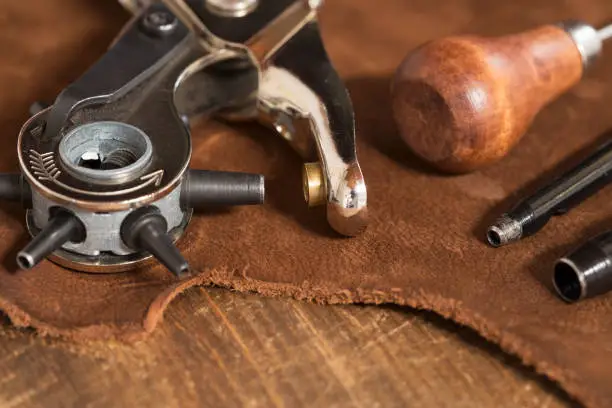 Leather craft tools on a brown leather background