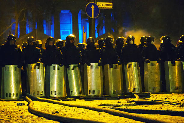 The riot police at Hrushevskogo street in Kiev, Ukraine Kiev, Ukraine - January 23, 2014: The riot police staying at Hrushevskogo street in Kiev, Ukraine. The anti-governmental protests were provoked when the Ukrainian president denied to sign an agreement with the EU. riot police stock pictures, royalty-free photos & images