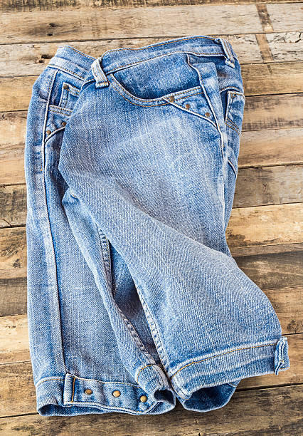 istock Blue jeans on old wooden surface 477999658
