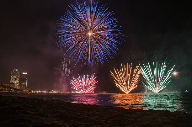 fuochi d'artificio su acqua visto dalla spiaggia, barcellona - spanish culture flash foto e immagini stock