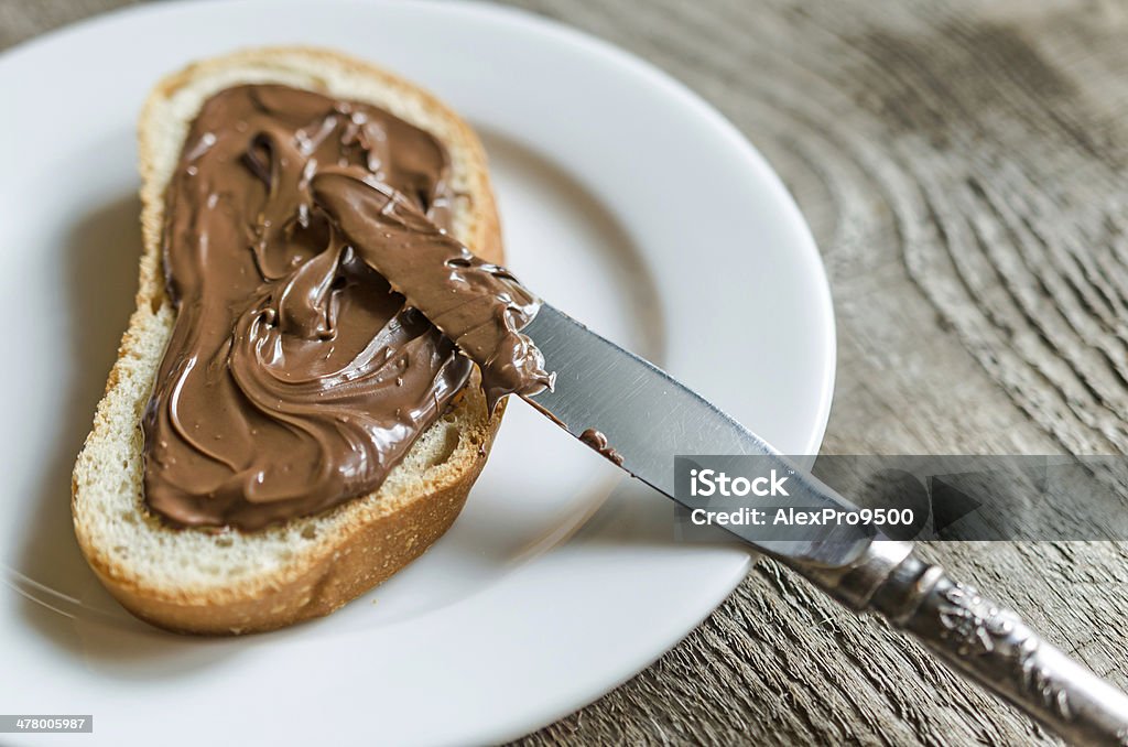 Fetta di pane con crema di cioccolato - Foto stock royalty-free di Dolci