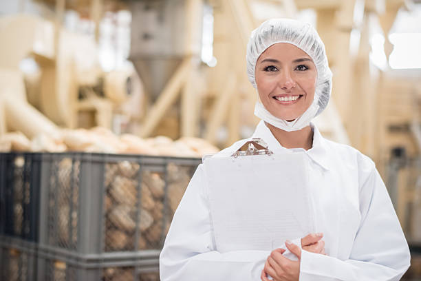 mujer que trabaja en una fábrica de pan - food hygiene fotografías e imágenes de stock