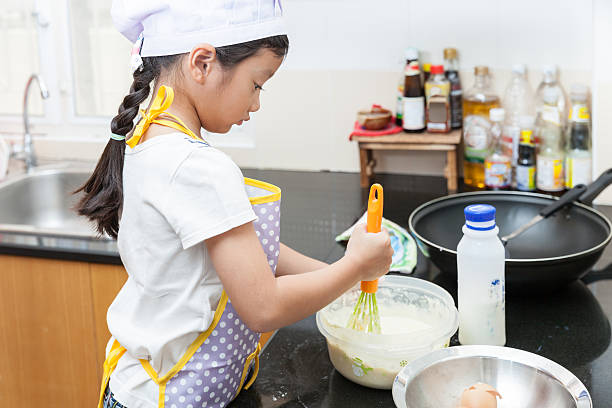 istock Little asian girl making pancake 478007360