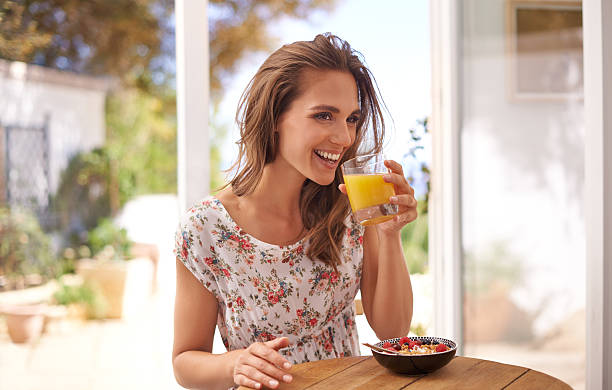 goditi una prima colazione equilibrata - women juice drinking breakfast foto e immagini stock