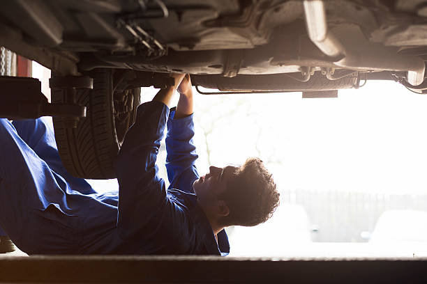 держа занятых в гараже - car examining mechanic auto mechanic стоковые фото и изображения