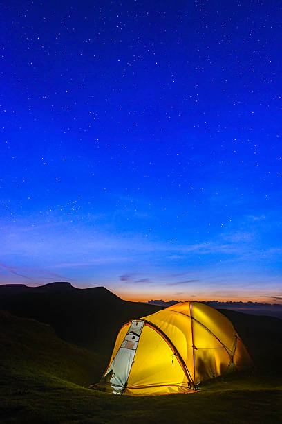 istock Stars shining over yellow dome tent illuminated in mountain camp 478007902
