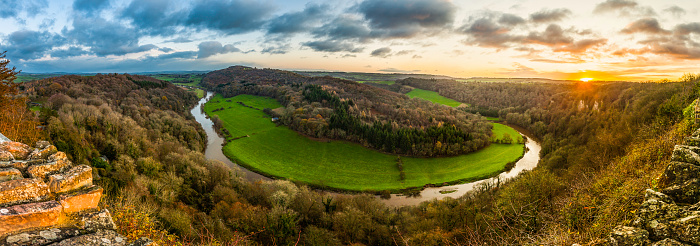 Golden sunrise over the woodlands and green meadows of this picturesque valley with the River Wye meandering slowly through the Forest of Dean, rural Gloucestershire, Herefordshire countryside and the rolling patchwork landscape of the Welsh borders. ProPhoto RGB profile for maximum color fidelity and gamut.