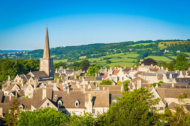 chiesa guglia nel grazioso villaggio di cotswold cottage verde campi estivi - english village immagine foto e immagini stock