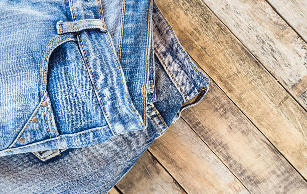 istock Blue jeans on old wooden surface 478010474