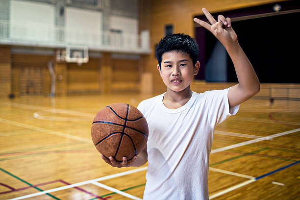 istock Japanese school boy playing basketball 478011468