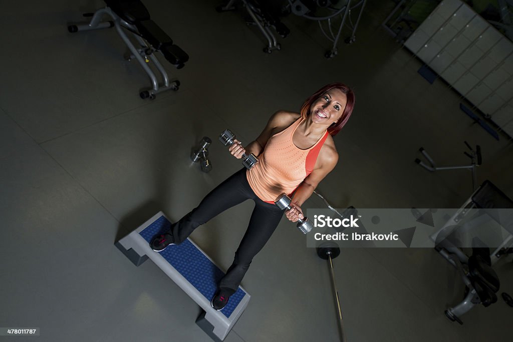 Sollevamento pesi femminile con felice espressione - Foto stock royalty-free di Adulto