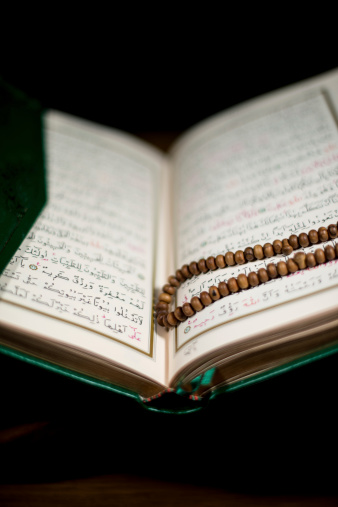 pages of holy koran and prayer beads at the book