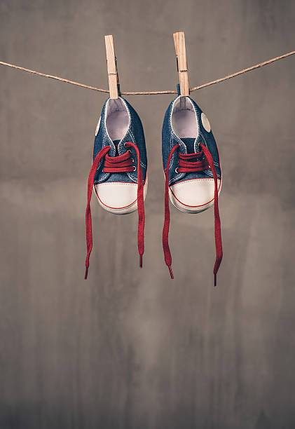 istock Baby sneakers hanging on the clothesline 478012842