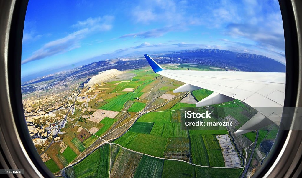 Blick aus dem Flugzeug-Fenster auf Felder und die Berge - Lizenzfrei Flugzeug Stock-Foto