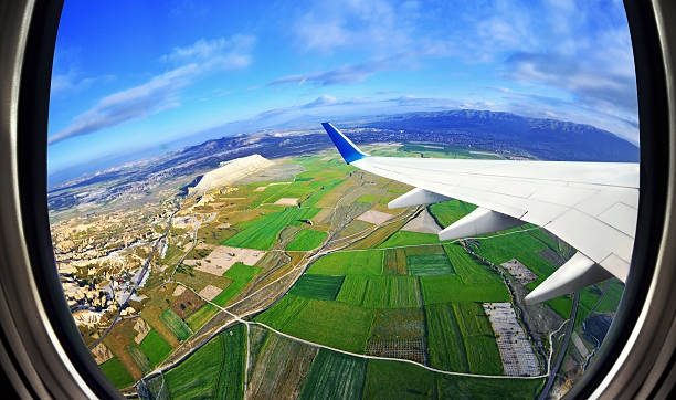 blick aus dem flugzeug-fenster auf felder und die berge - jet rockband stock-fotos und bilder