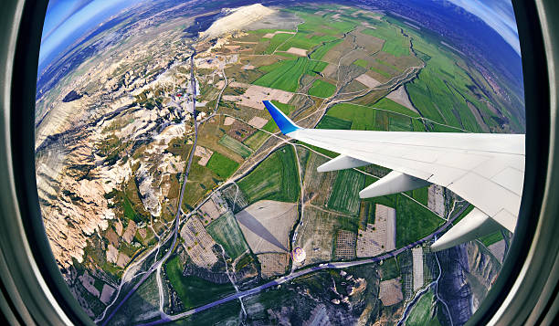 avião vista da janela sobre campos e montanhas - mountain range earth sky airplane imagens e fotografias de stock