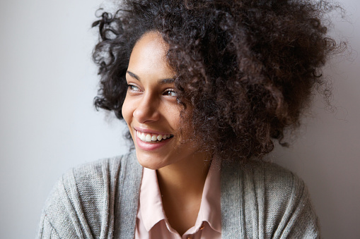 Close up portrait of a beautiful black woman smiling and looking away