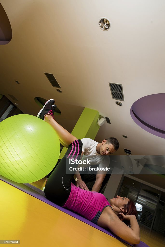 Mujer joven haciendo Crunches en un gimnasio - Foto de stock de Acostado libre de derechos