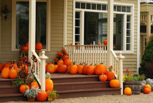 Autumnal porch decorated with pumpkins.