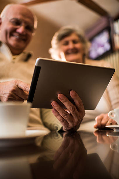 istock Below view of seniors using digital tablet in a cafe. 478022004