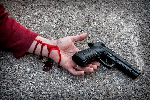 istock Man with gun in hand bloodstained lies dead 478022685