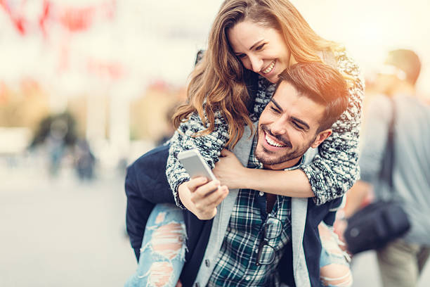 istock Man carrying his girlfriend on piggyback for selfie 478024930