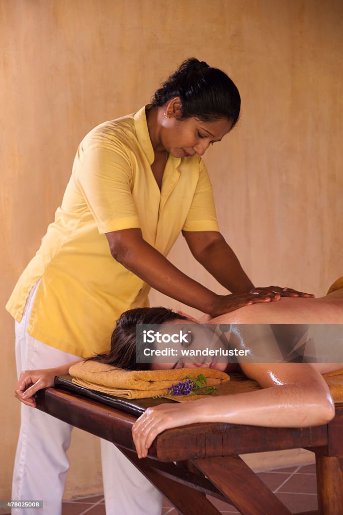 Sri Lankan woman giving an Ayurveda treatment Woman receiving an Ayurveda herbal oil body massage, an ancient form of healing and well-being, Sri Lanka, Asia Ayurveda Stock Photo